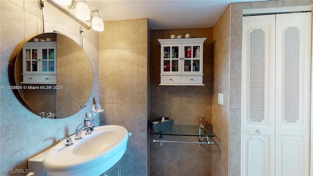 bathroom with sink and tile walls