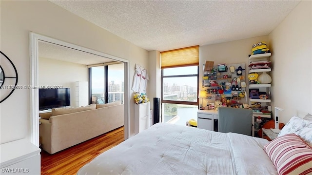 bedroom featuring light hardwood / wood-style floors and a textured ceiling