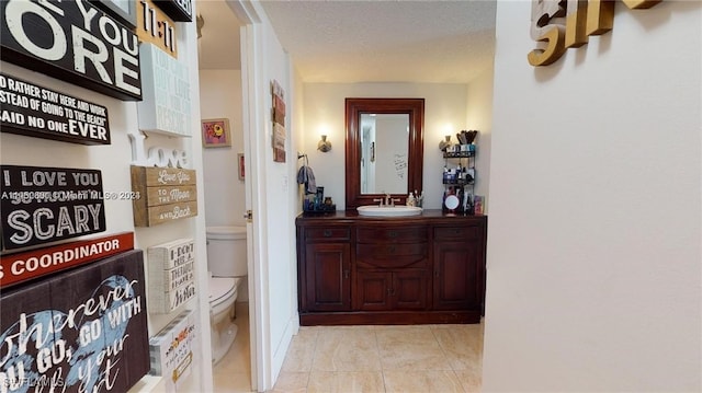 corridor featuring sink, a textured ceiling, and light tile patterned flooring