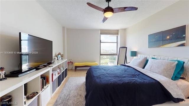 bedroom with ceiling fan and a textured ceiling