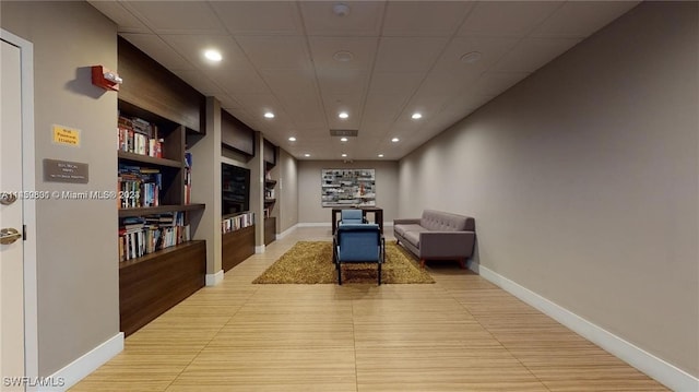 interior space with a paneled ceiling and built in features