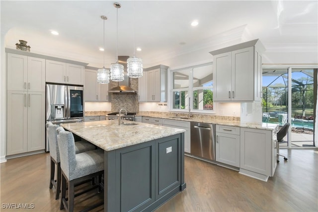 kitchen featuring a breakfast bar area, stainless steel appliances, ornamental molding, light stone countertops, and dark wood-style floors