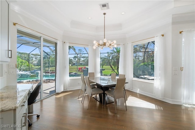 sunroom / solarium featuring a raised ceiling, a healthy amount of sunlight, and visible vents