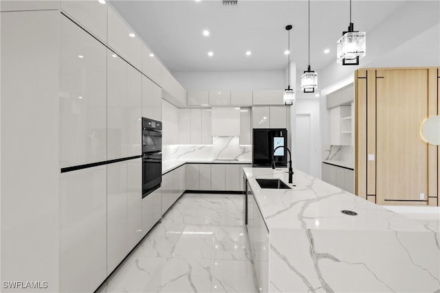 kitchen with pendant lighting, sink, light stone counters, black appliances, and white cabinets