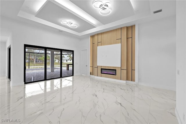 unfurnished living room featuring a tray ceiling