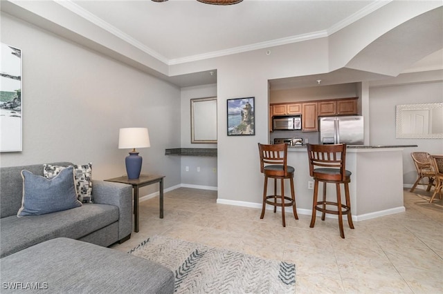 living area with light tile patterned floors, baseboards, and crown molding