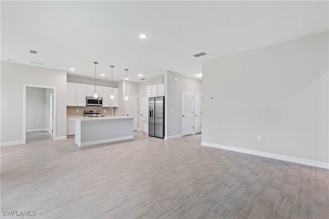 unfurnished living room featuring sink and light wood-type flooring