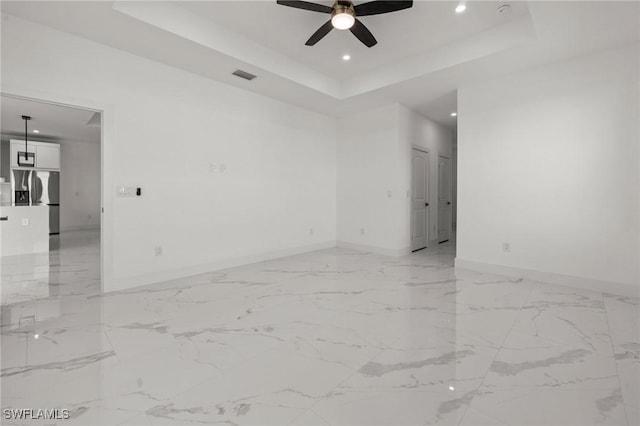 unfurnished room featuring ceiling fan and a tray ceiling