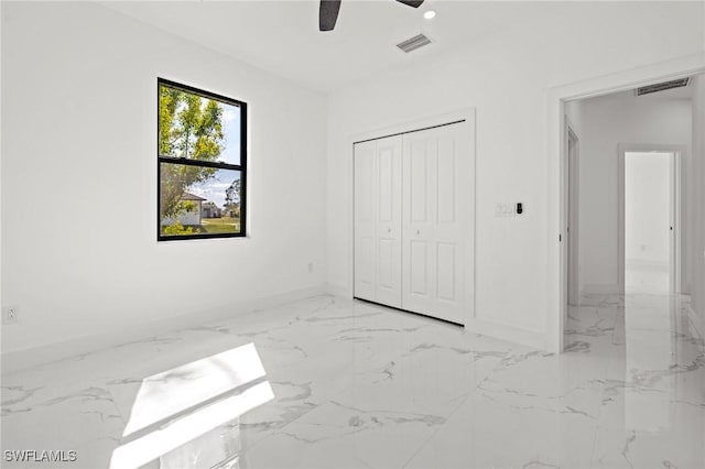 unfurnished bedroom featuring ceiling fan and a closet