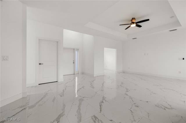 unfurnished room featuring a tray ceiling and ceiling fan