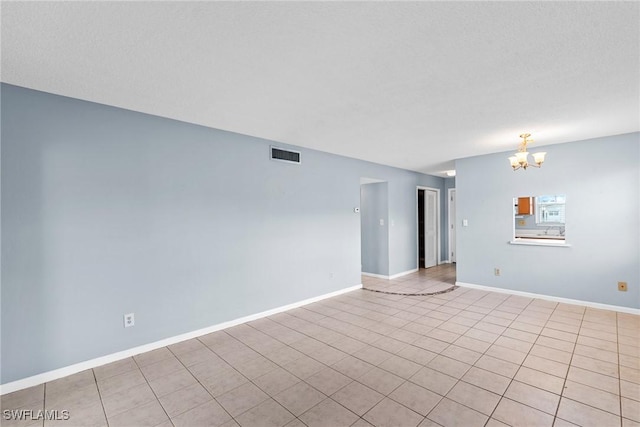 tiled empty room with a chandelier