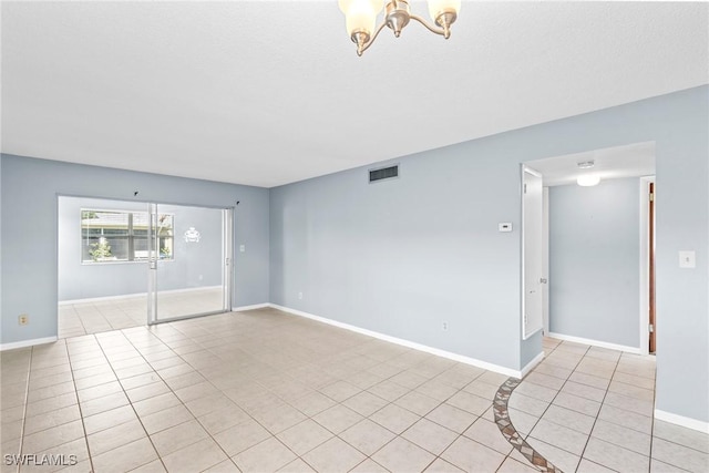 unfurnished room featuring light tile patterned flooring and a notable chandelier