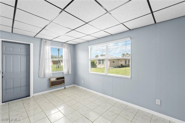 unfurnished room with a drop ceiling and heating unit