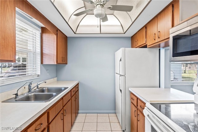 kitchen featuring sink, white electric range, light tile patterned floors, ceiling fan, and a healthy amount of sunlight