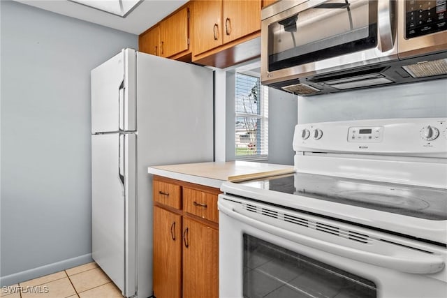 kitchen featuring light tile patterned floors and white appliances