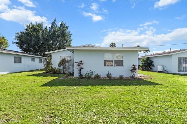 rear view of property featuring a lawn