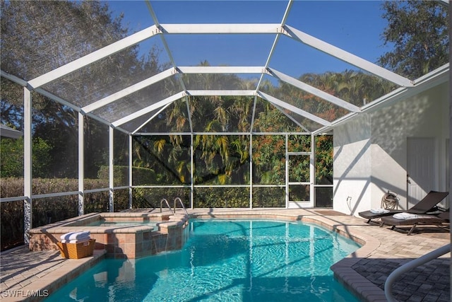 view of swimming pool with a patio area, glass enclosure, and an in ground hot tub