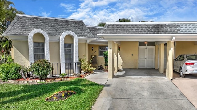 view of front of house featuring a carport and a front yard