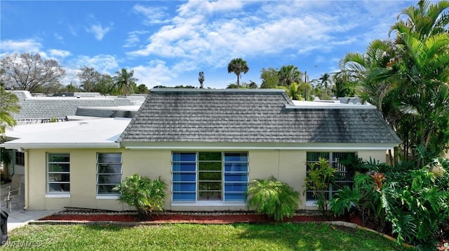 rear view of house featuring a yard