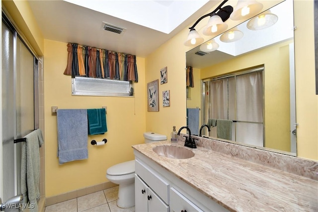 bathroom featuring vanity, a shower with door, tile patterned floors, and toilet