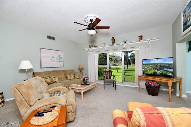 carpeted living room with ceiling fan and a textured ceiling