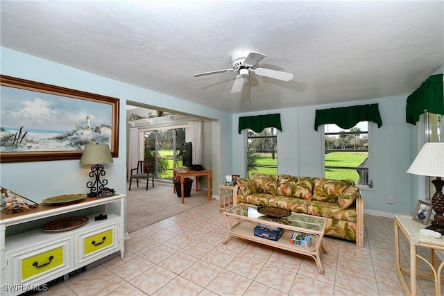 tiled living room with a textured ceiling and ceiling fan