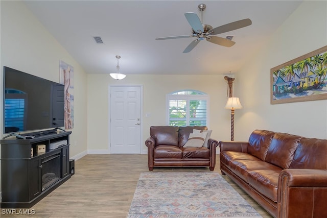 living room with lofted ceiling, light hardwood / wood-style floors, and ceiling fan