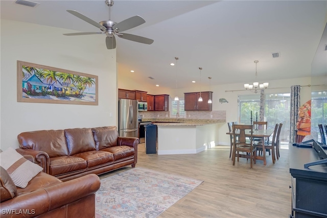 living room with sink, ceiling fan with notable chandelier, and light wood-type flooring