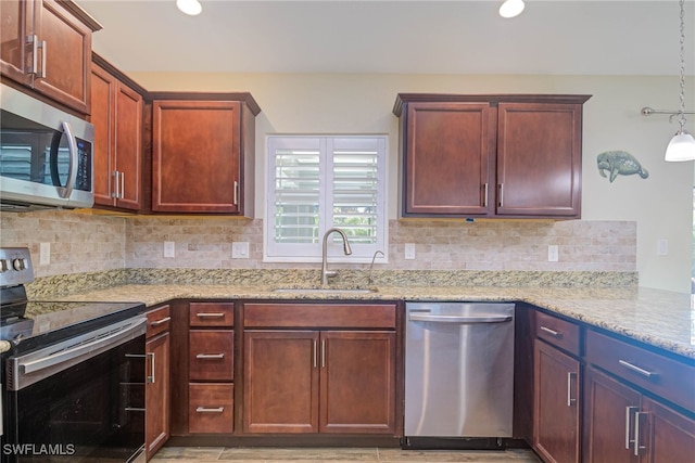 kitchen with sink, decorative backsplash, hanging light fixtures, stainless steel appliances, and light stone countertops