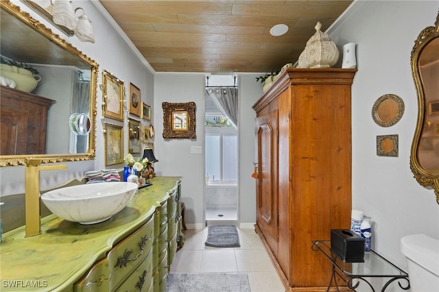 bathroom featuring tile patterned flooring, vanity, ornamental molding, toilet, and walk in shower