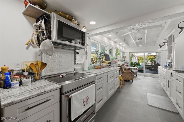 kitchen featuring beamed ceiling, white cabinetry, appliances with stainless steel finishes, and light stone counters