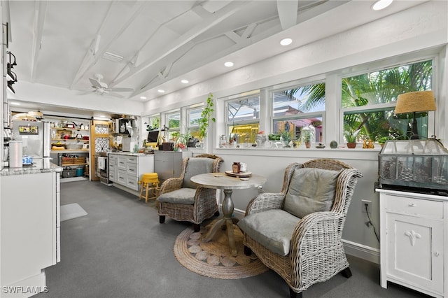 sitting room with ceiling fan and vaulted ceiling with beams