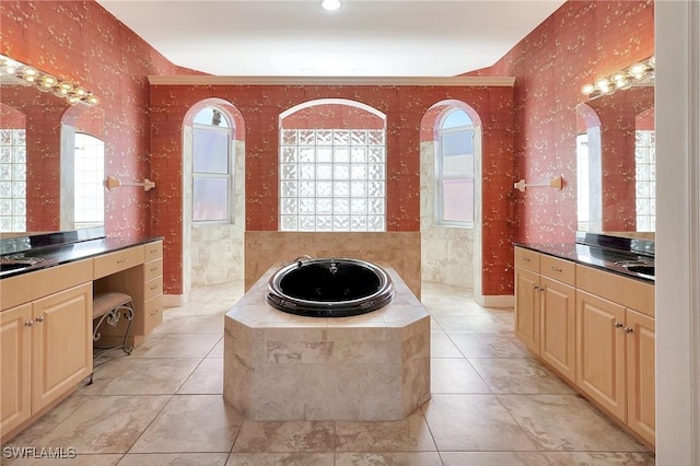 bathroom featuring a relaxing tiled tub, plenty of natural light, tile patterned flooring, and vanity