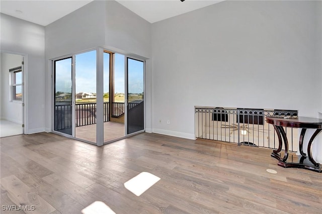 interior space with light hardwood / wood-style flooring and a high ceiling