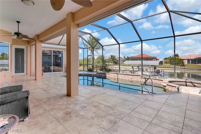 view of swimming pool with ceiling fan, a patio, a water view, glass enclosure, and an in ground hot tub