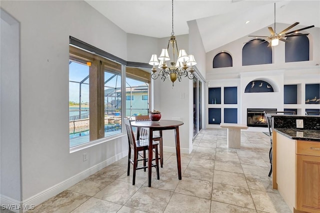 dining room with light tile patterned floors, ceiling fan with notable chandelier, high vaulted ceiling, a water view, and built in shelves