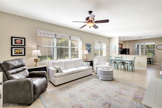 living room featuring a wealth of natural light, ceiling fan, and light tile patterned flooring