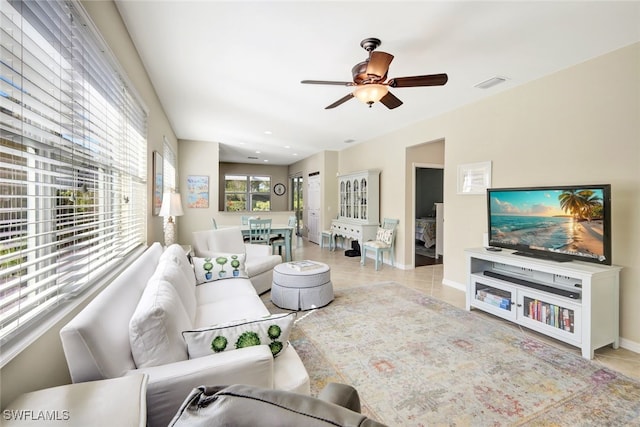 living room featuring light tile patterned floors and ceiling fan