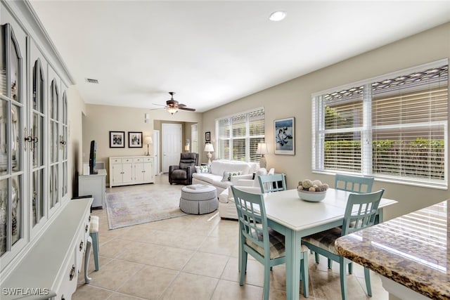 dining space with a healthy amount of sunlight, visible vents, a ceiling fan, and light tile patterned flooring