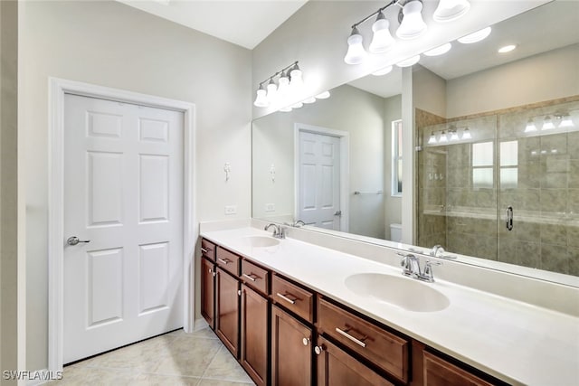 bathroom with vanity, tile patterned flooring, a shower with door, and toilet