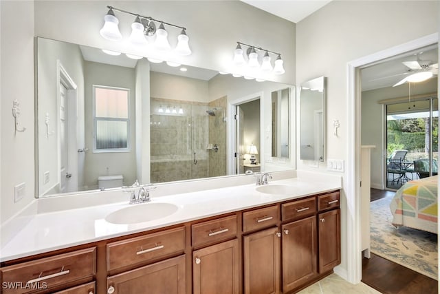 bathroom featuring vanity, ceiling fan, a shower with shower door, and toilet