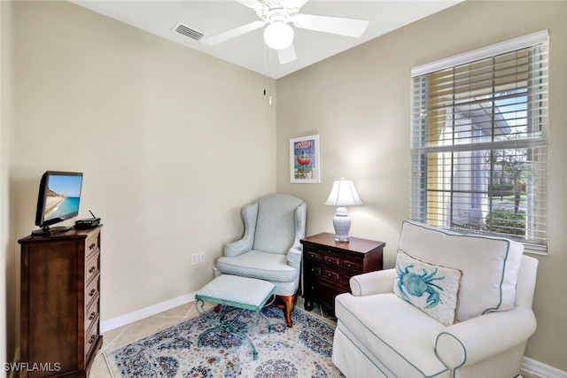 sitting room featuring light tile patterned floors, ceiling fan, visible vents, and baseboards