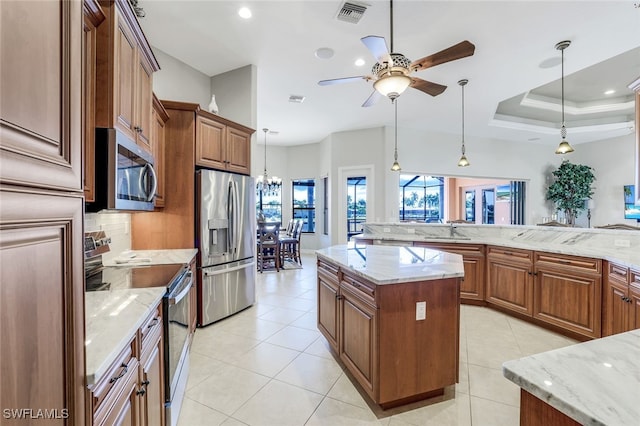 kitchen featuring light stone counters, sink, stainless steel appliances, and a kitchen island