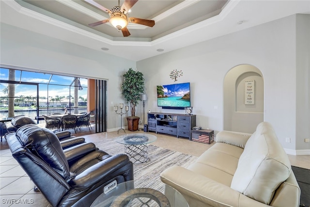 tiled living room featuring crown molding, ceiling fan, and a tray ceiling