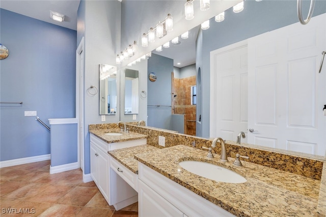 bathroom featuring vanity, tile patterned floors, and tiled shower