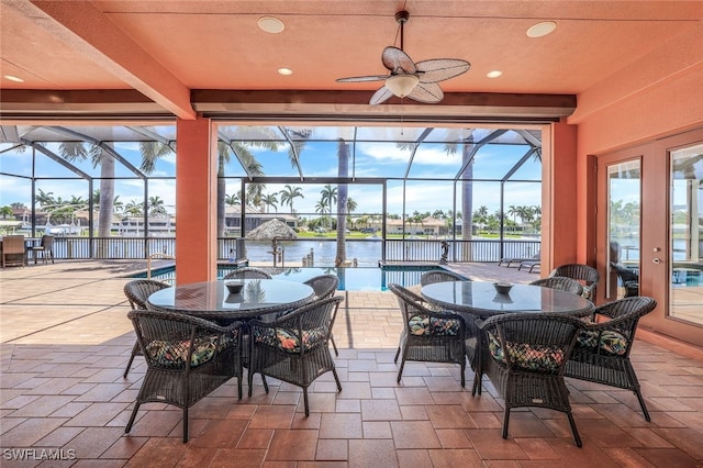 sunroom / solarium with beamed ceiling, a water view, and ceiling fan