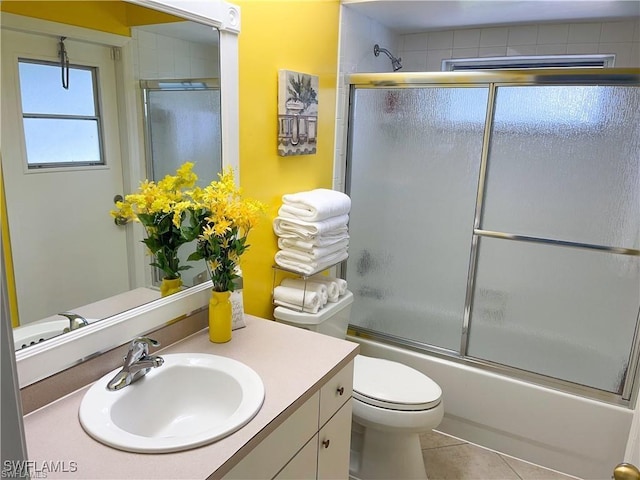 full bathroom with enclosed tub / shower combo, vanity, toilet, and tile patterned flooring