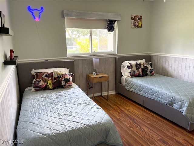 bedroom featuring hardwood / wood-style flooring and wooden walls