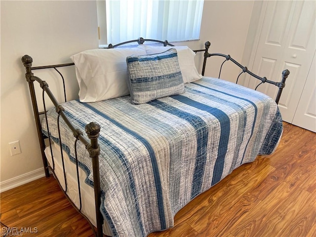 bedroom with dark hardwood / wood-style flooring