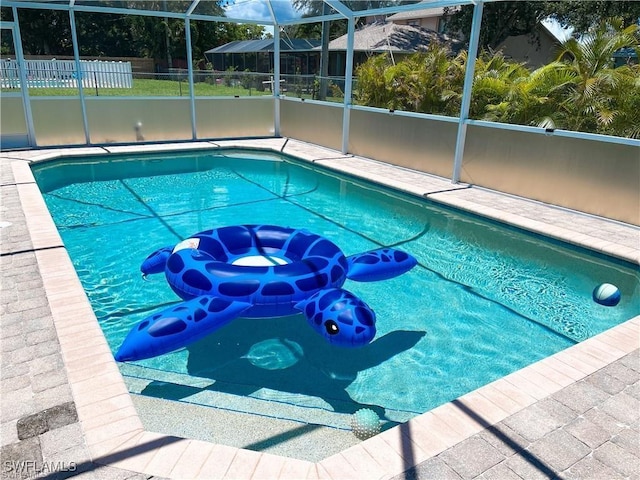 view of pool with glass enclosure